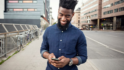 Hombre sonriente usando su celular